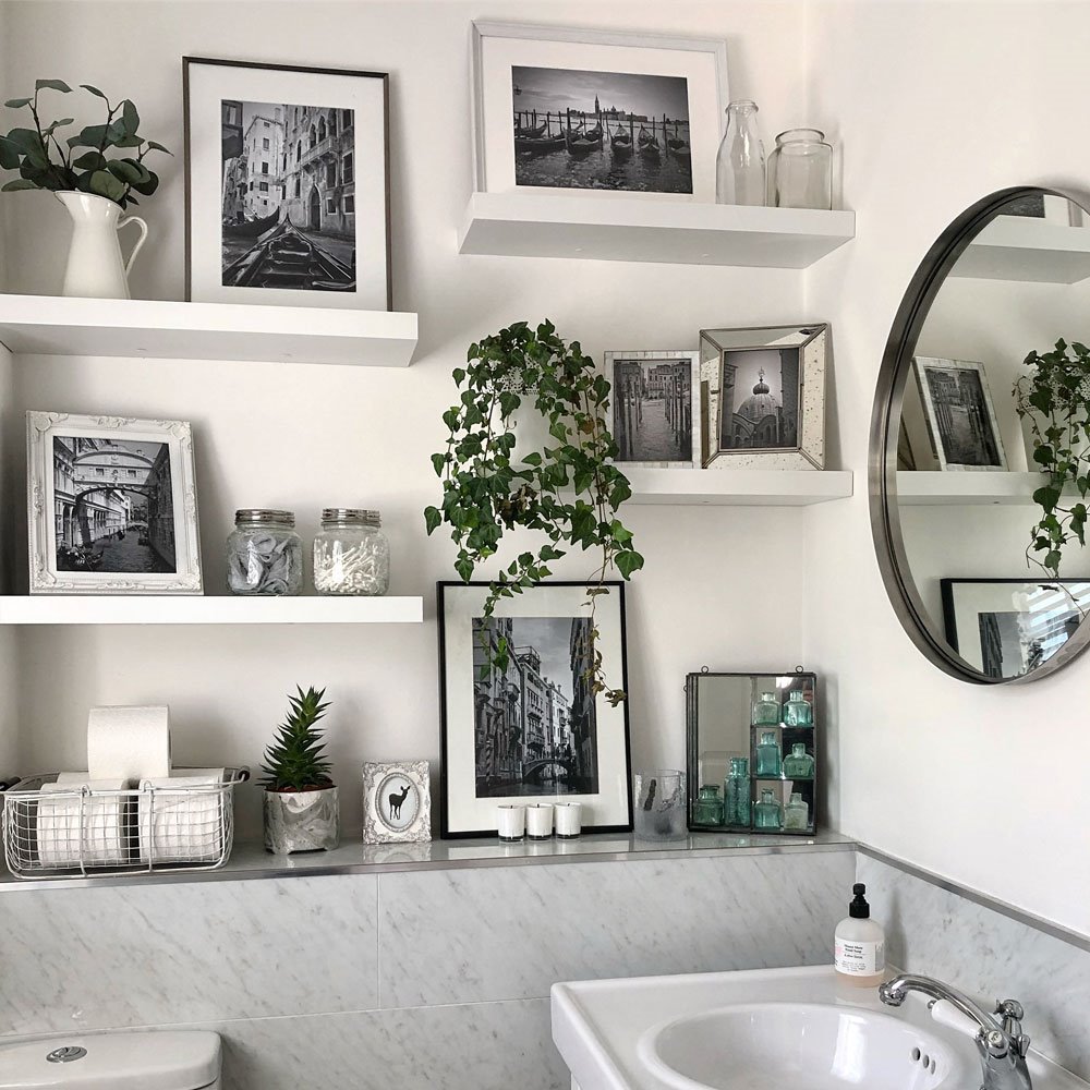 Baño con estanterias decoradas con cuadros