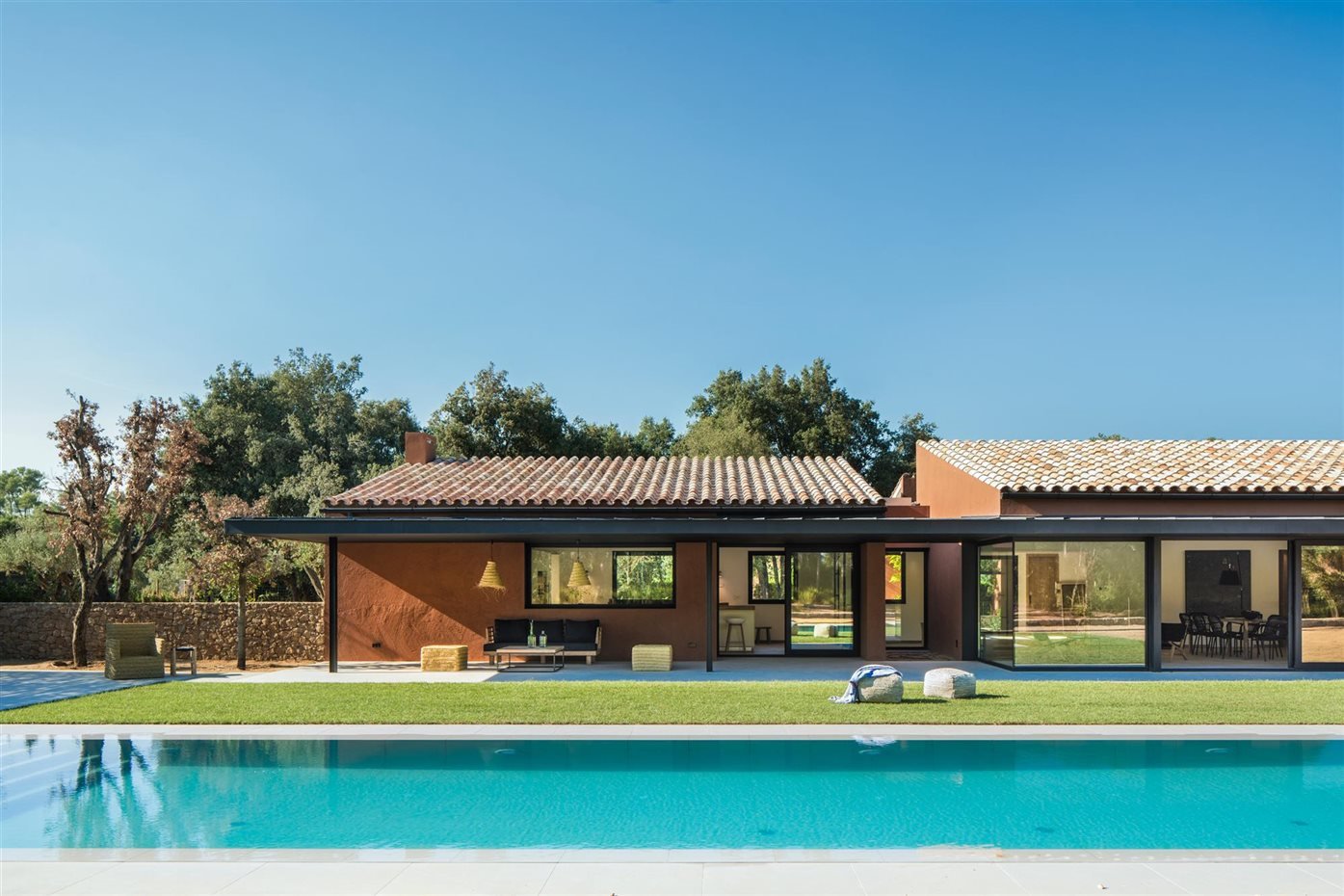 Casa en el campo con techo de tejas de color rojo y paredes de terracota con piscina