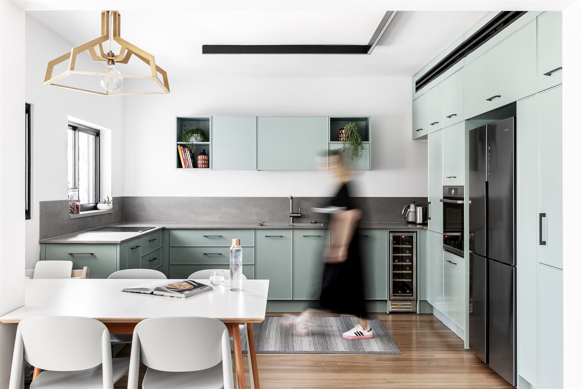 Cocina con muebles de color azul turquesa y lampara de madera