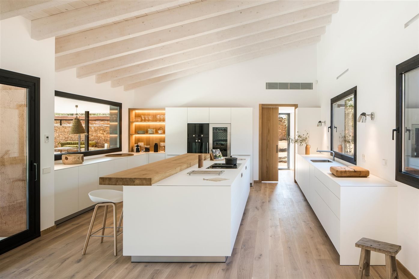 Cocina con vigas blancas y taburete de color blanco