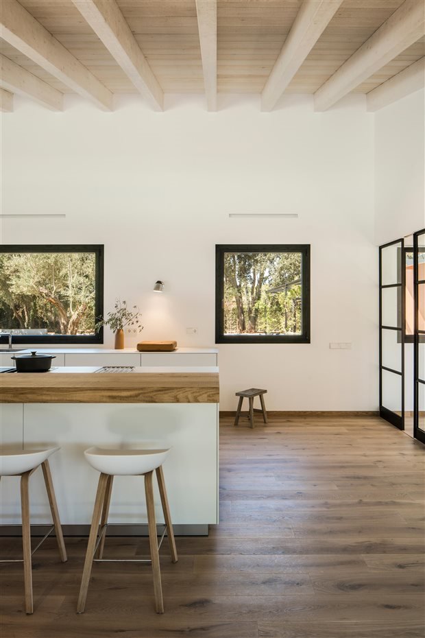 Cocina con vigas de color blanco taburetes blancos con patas de madera