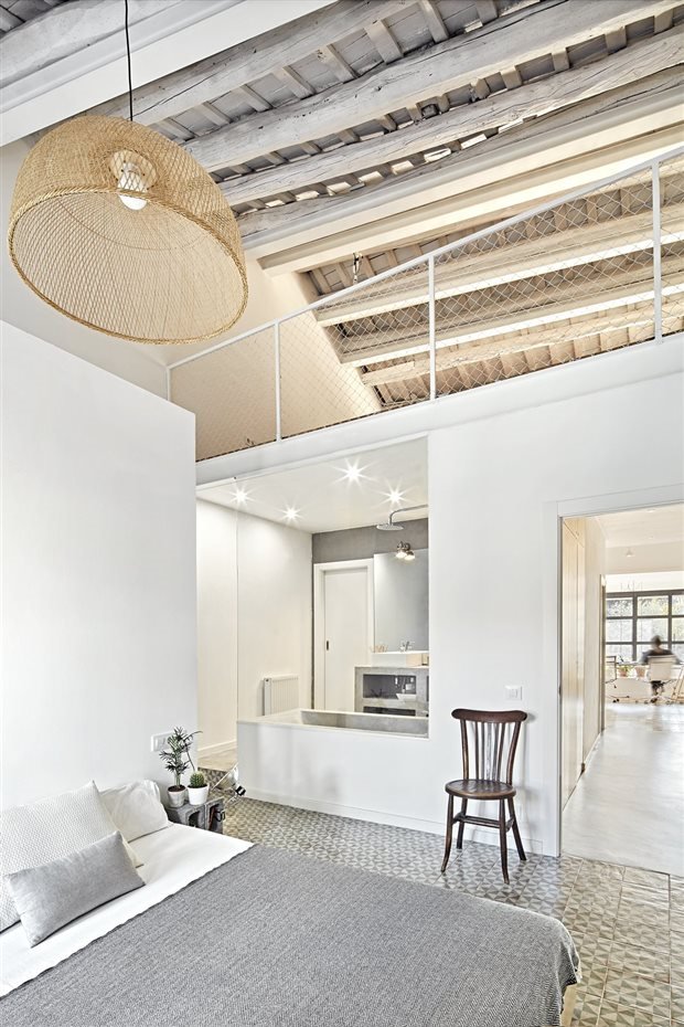 Dormitorio con lampara de fibras naturales y vigas de color blanco