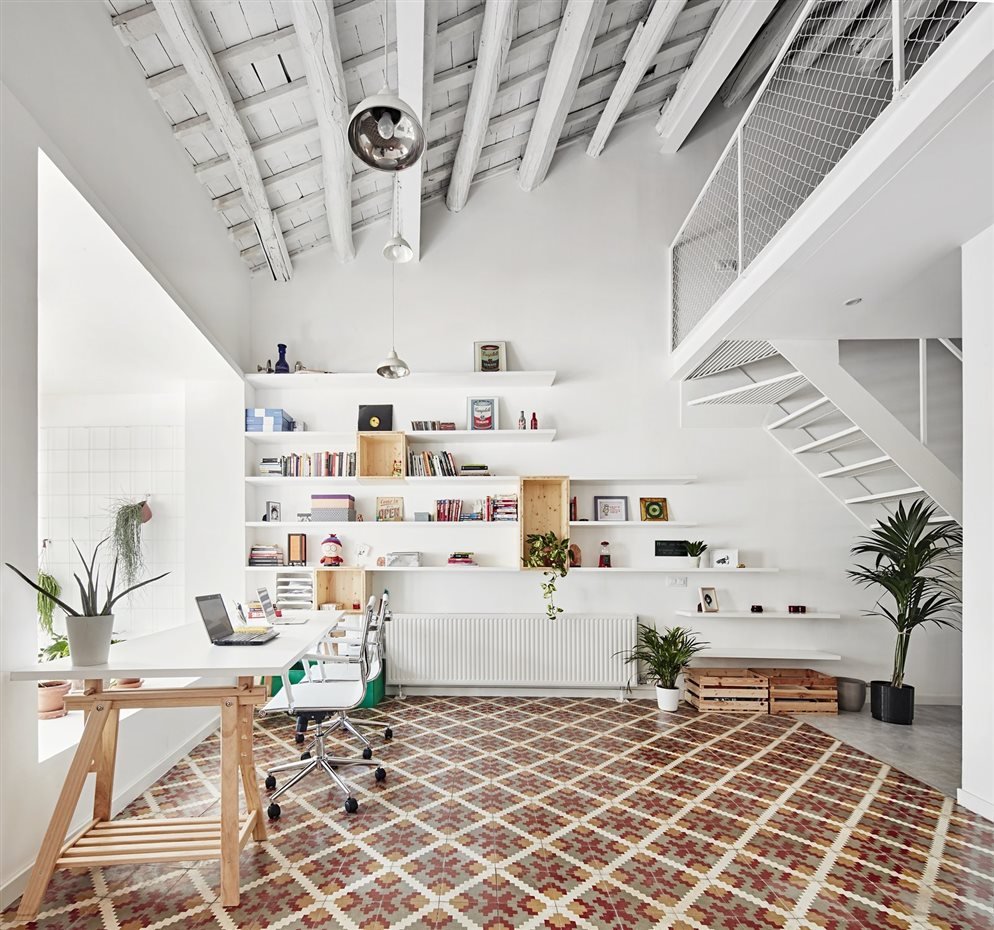 Estudio con suelo hidraulico y vigas de madera pintadas en color blanco