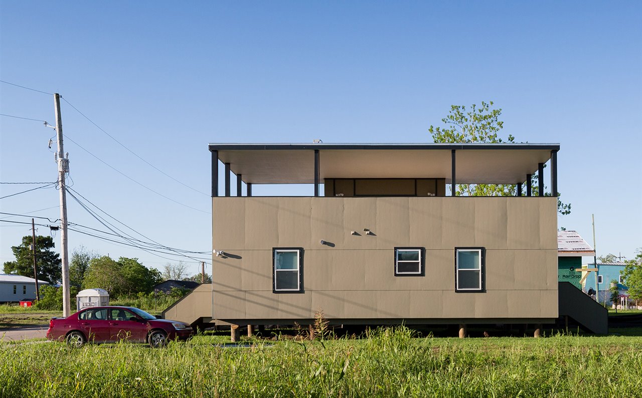 La casa de David Adjaye para Make it Right presenta una terraza elevada protegida de la lluvia por una cubierta sostenida por pilares.