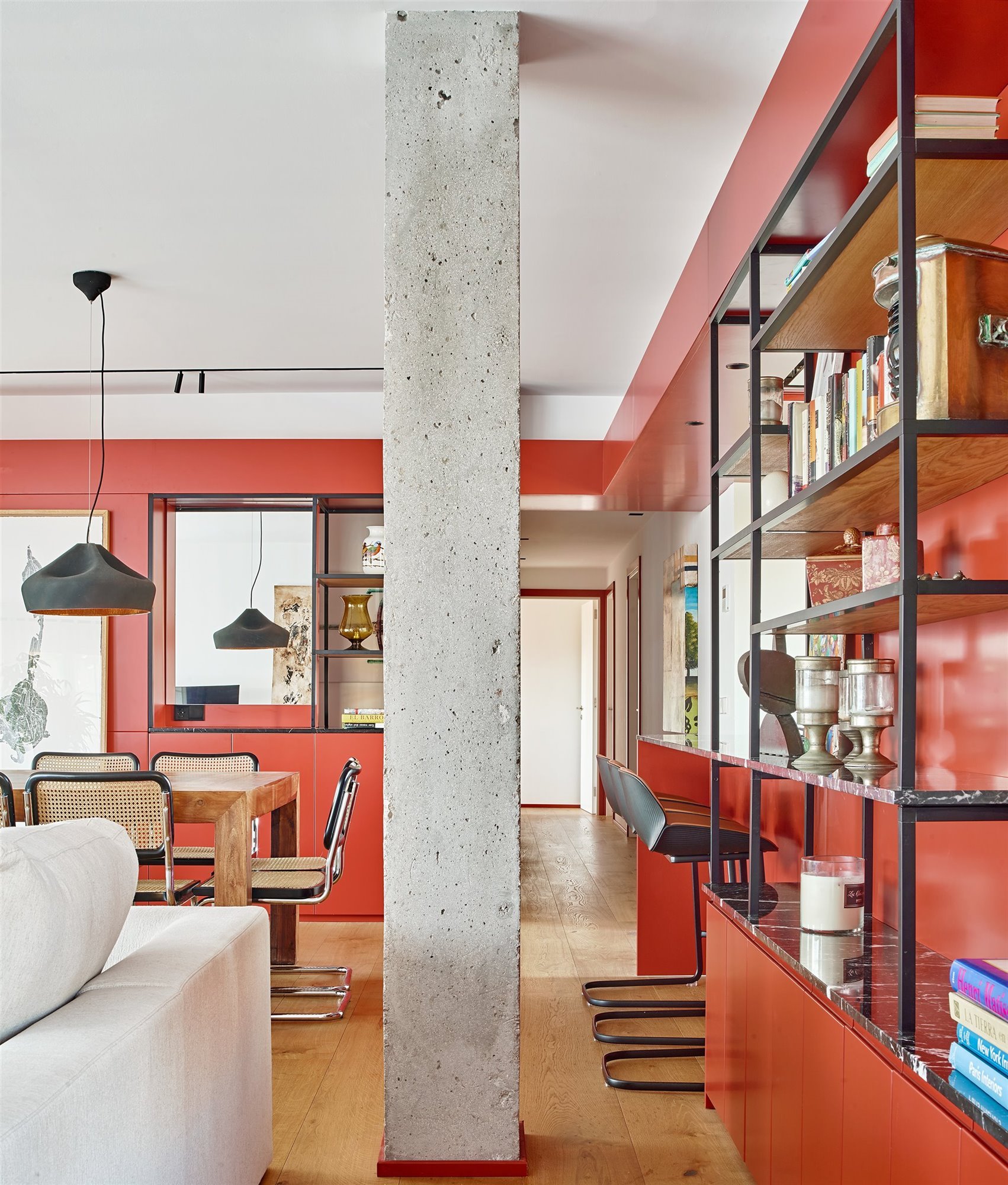 Piso con columna de granito y muebles de obra de color rojo