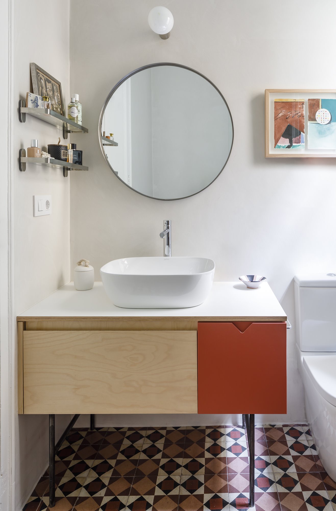 Baño con mueble de madera y suelo hidraulico  de un piso en Barcelona