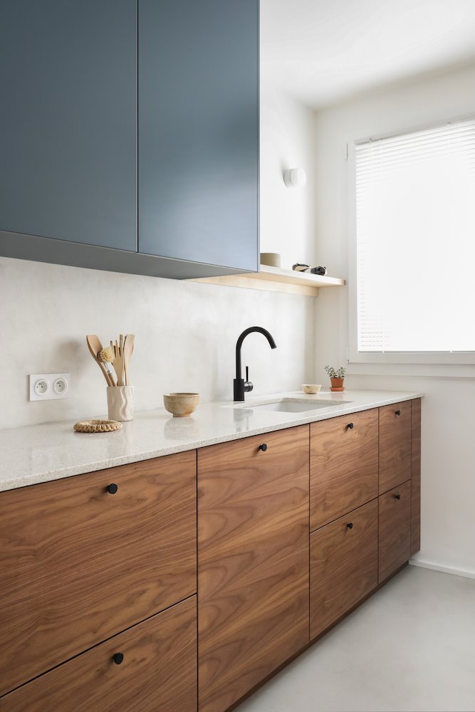 Cocina con muebles de madera y de color azul y encimera de granito