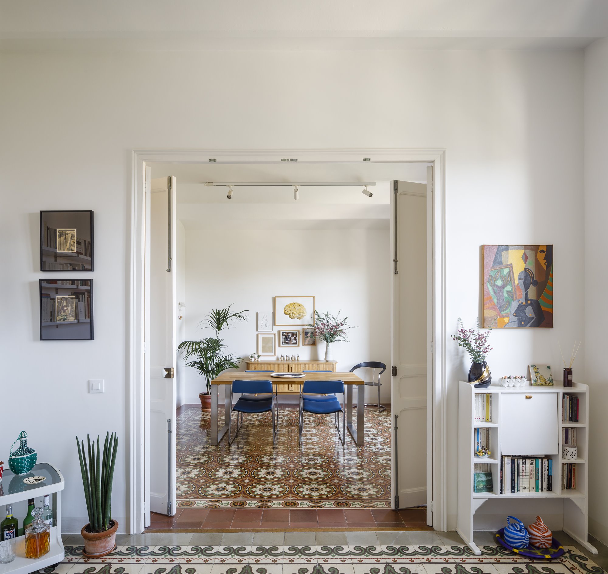 Comedor con puertas de color blanco y suelo hidraulico  de un piso en Barcelona