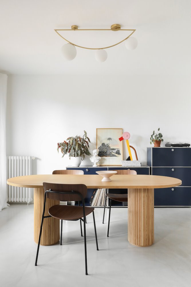 Comedor de un apartamento en Paris con mesa de madera y lampara dorada