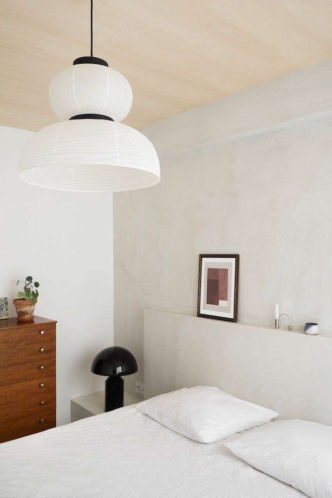 Dormitorio con cabecero de obra y lampara de techo de papel