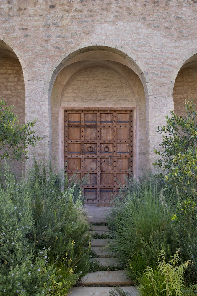 Entrada de piedra y madera de una casa en mitad del campo