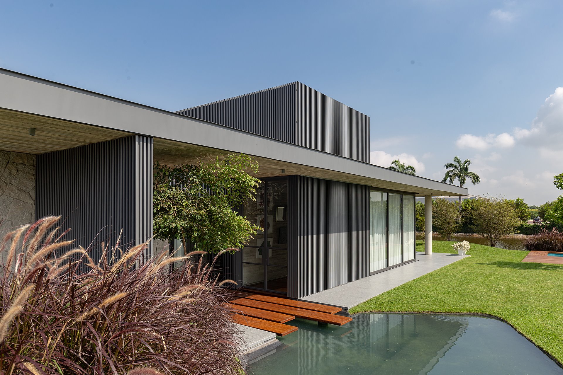 Fachada de metal de una casa moderna con un lago