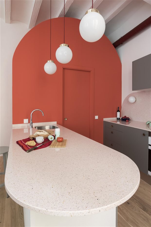 piso en barcelona con paredes de color rosa cocina con barra de granito