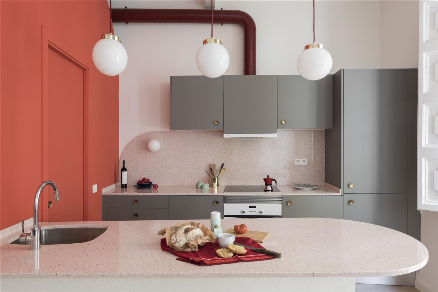 Cocina con muebles de color gris y coral de estilo industrial