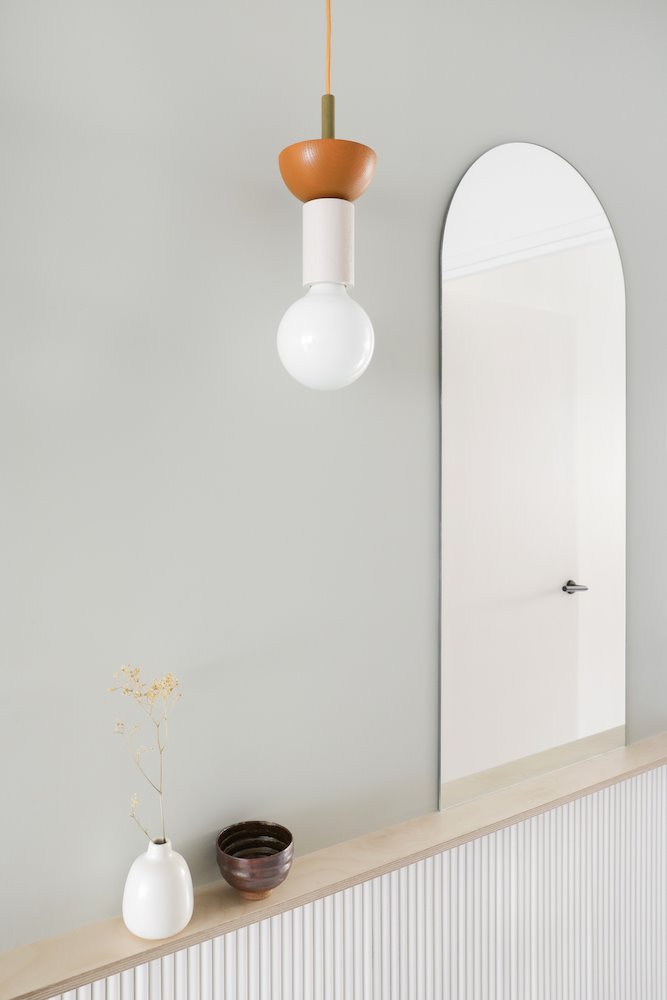 Piso en paris con repisa de madera y un espejo en forma de arco