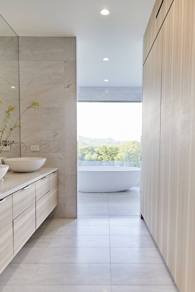 Baño con suelos de piedra y paredes de madera de una casa moderna