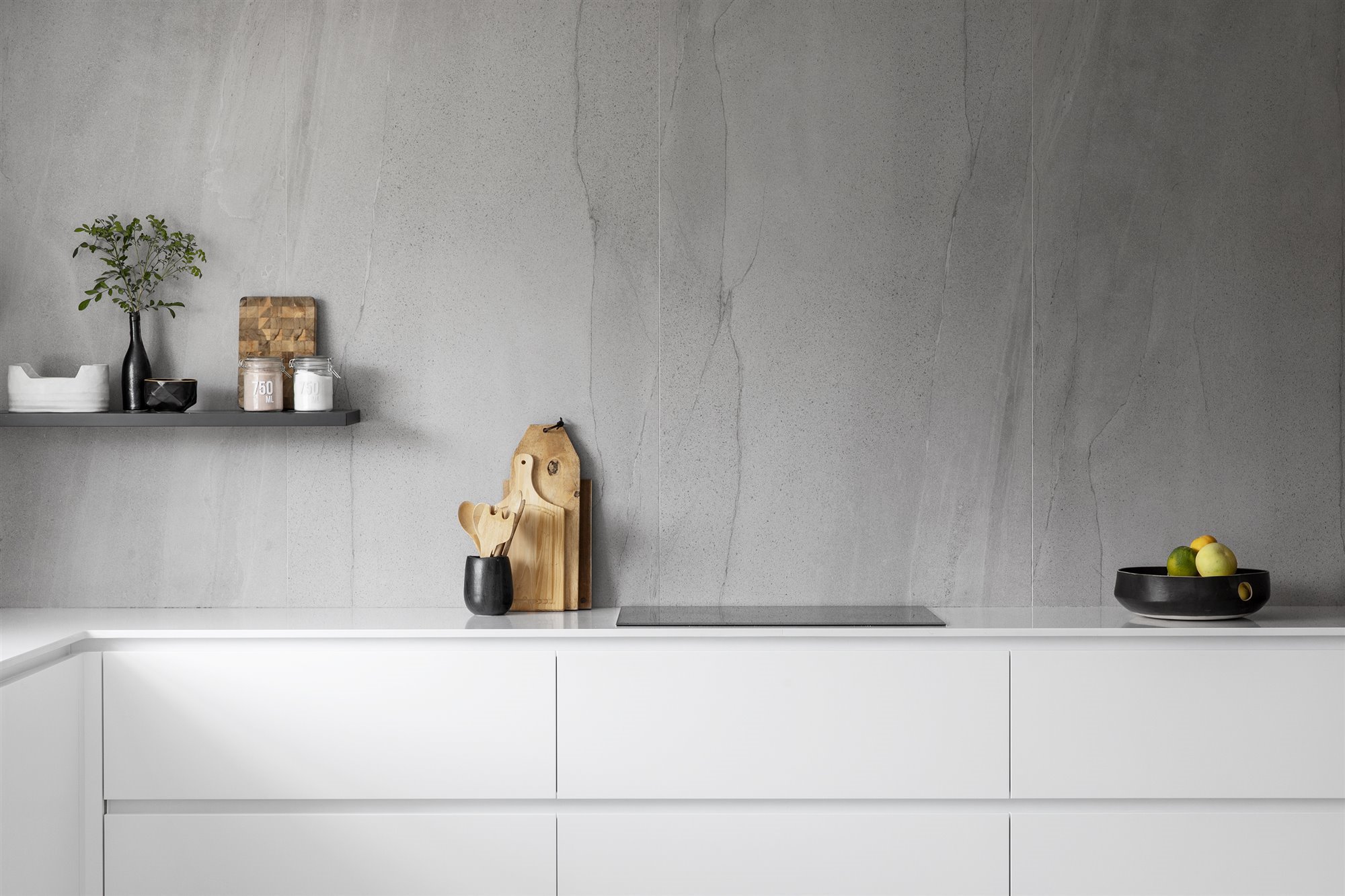 Cocina con paredes de granito y muebles de color blanco
