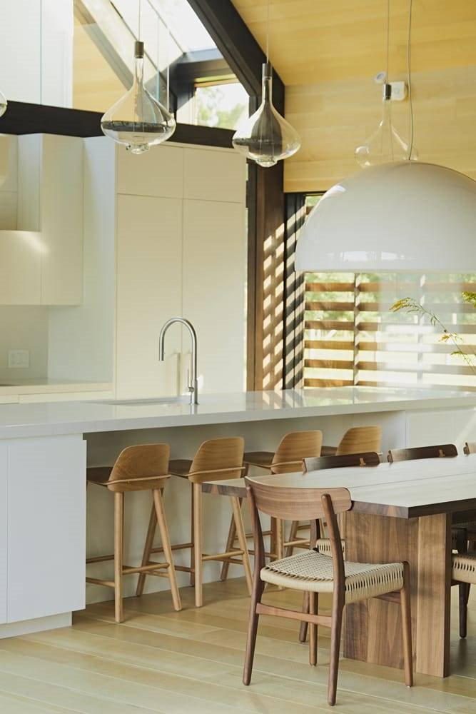 Cocina en isla con taburetes y comedor de un granero moderno