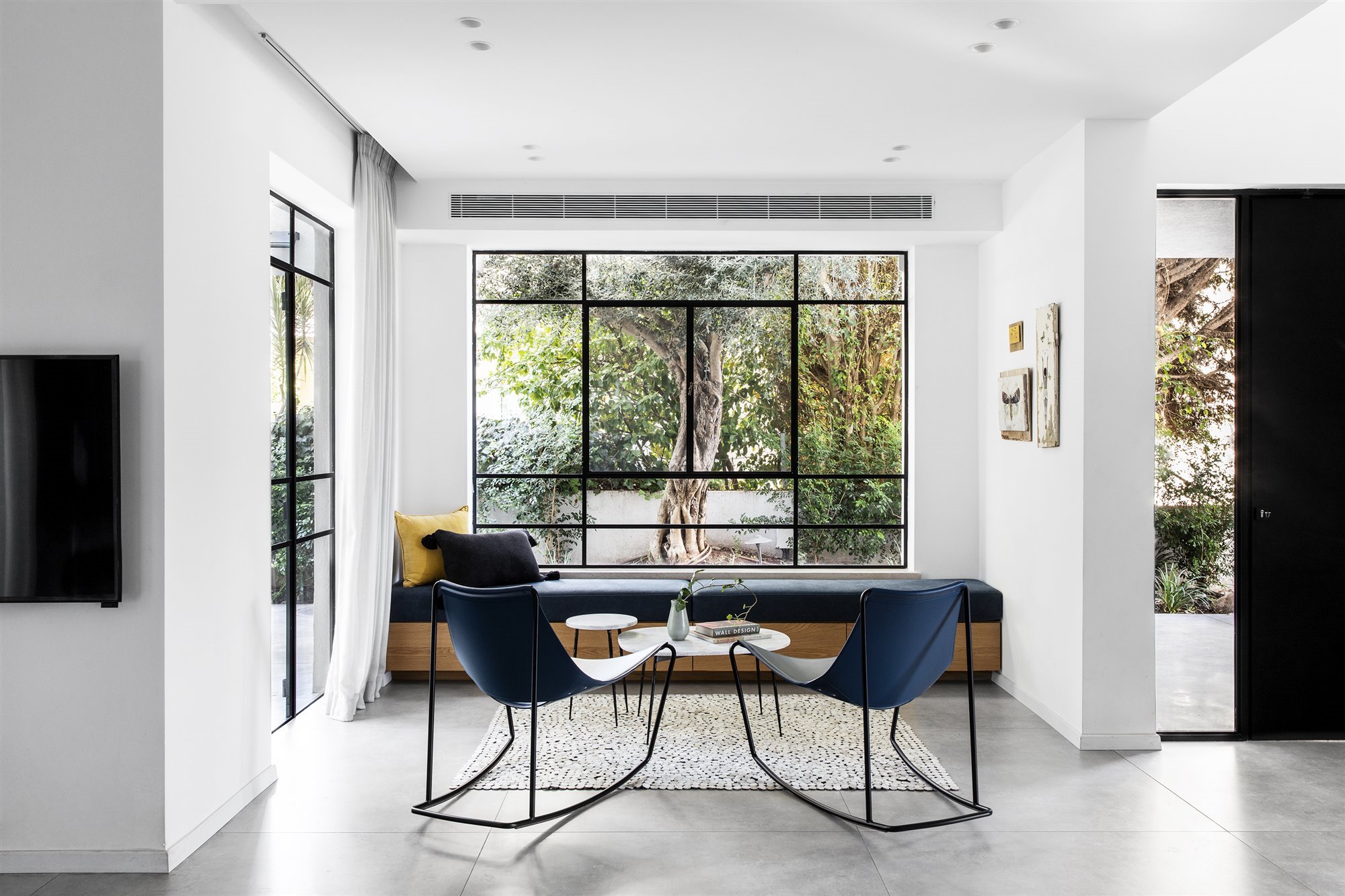 Comedor con dos sillas azules y banco junto a la ventana