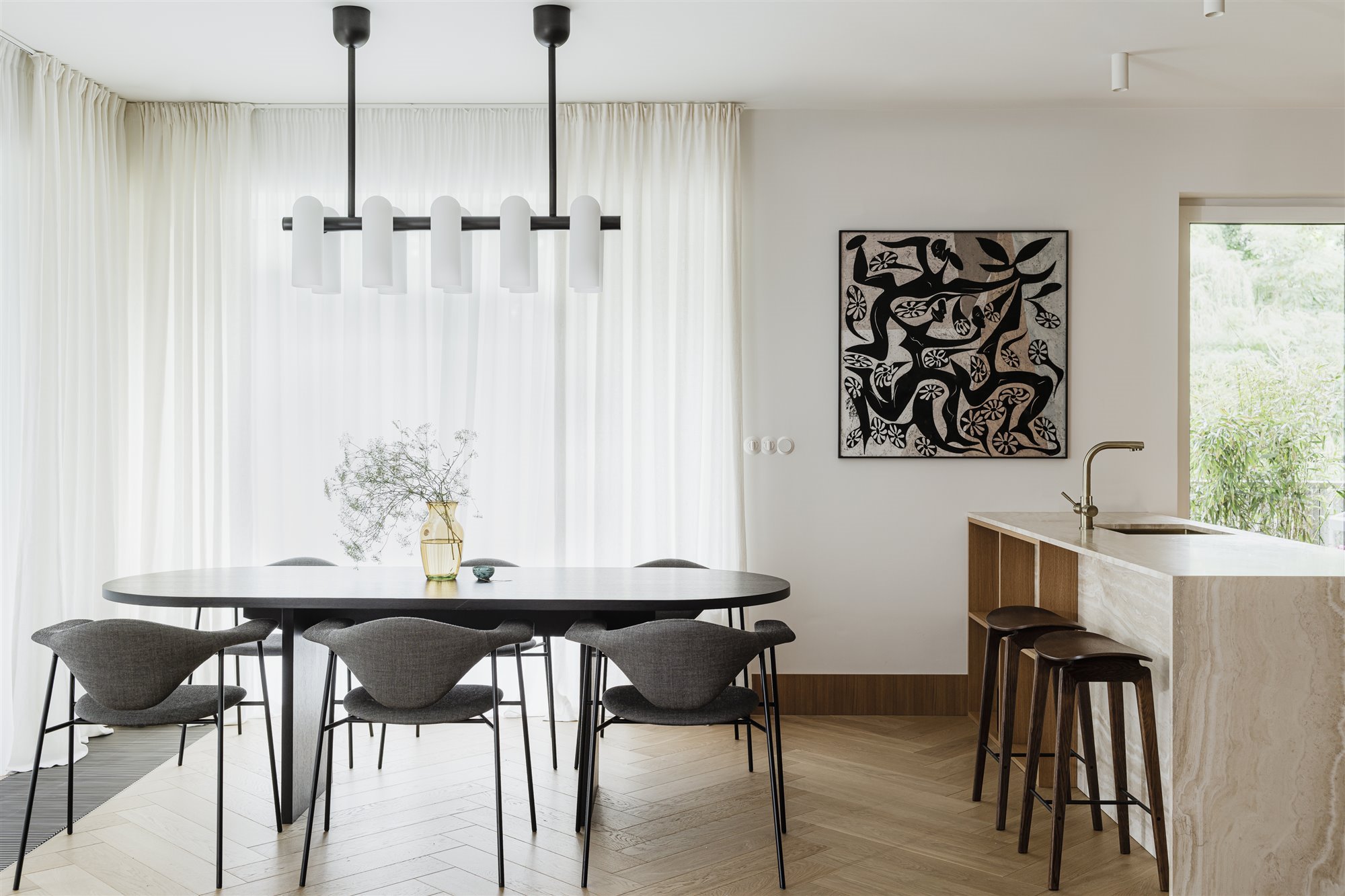 Comedor con lampara de techo y cocina con isla de madera
