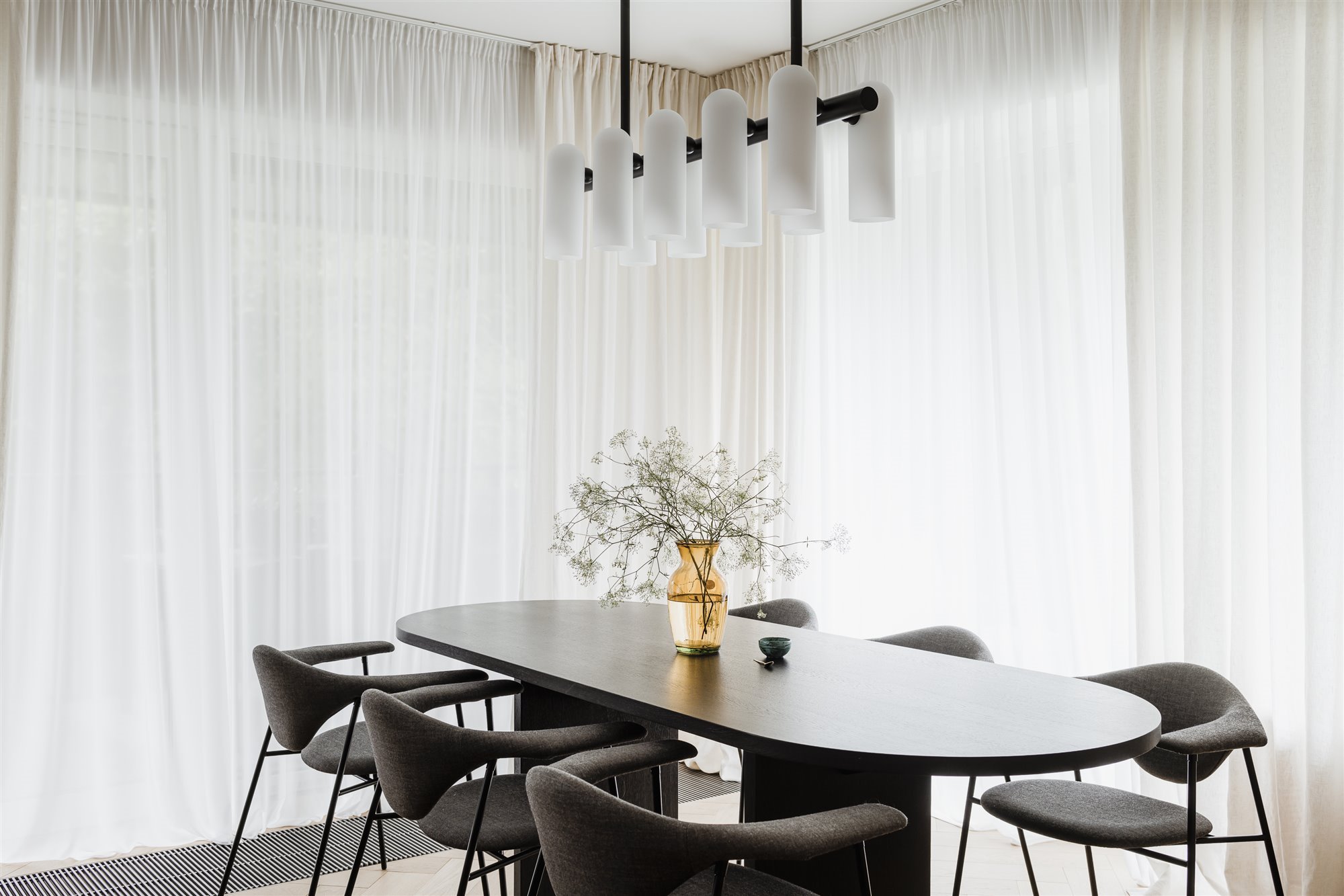 Comedor con lampara de techo y cortinas blancas