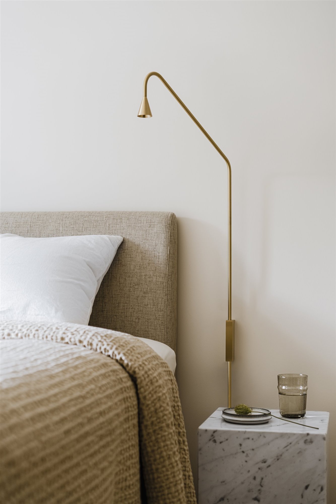 Dormitorio con cabecero y lampara de color dorado