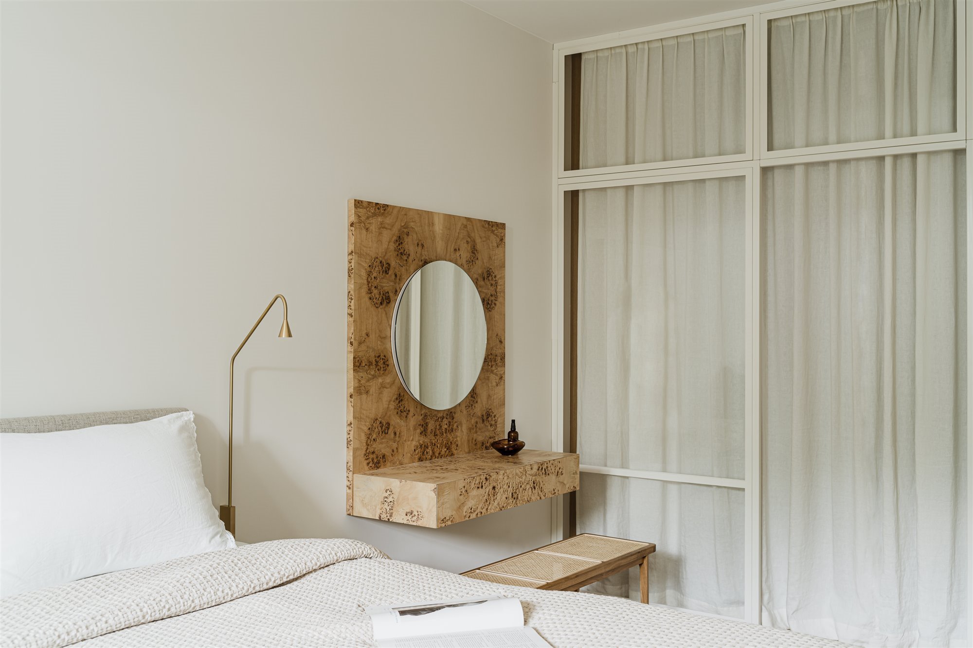 Dormitorio con escritorio de piedra y espejo redondo