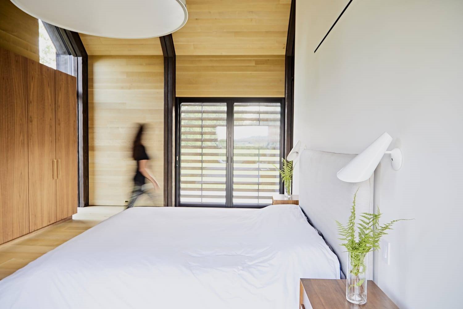 Dormitorio con paredes de madera de una casa moderna