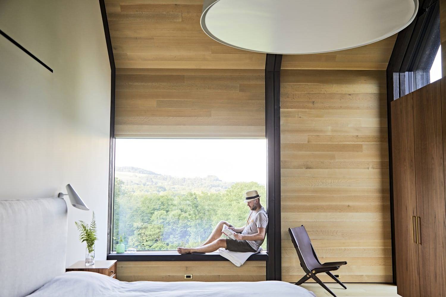 Dormitorio con vistas al campo de una casa moderna de madera