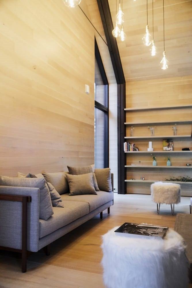 Salon con paredes de madera de una casa moderna en el campo