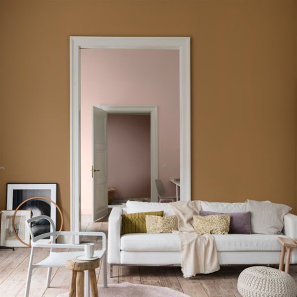 salon con paredes de color ocre y rosa y sofa blanco