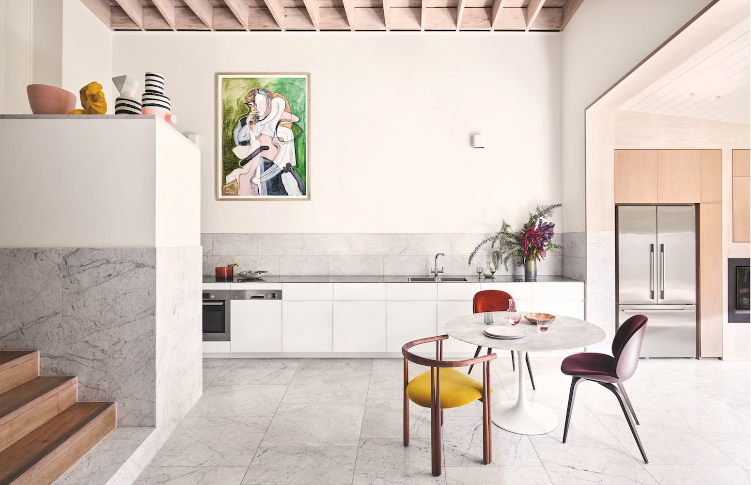 cocina abierta con techos con vigas mesa de comedor redonda con sillas de madera