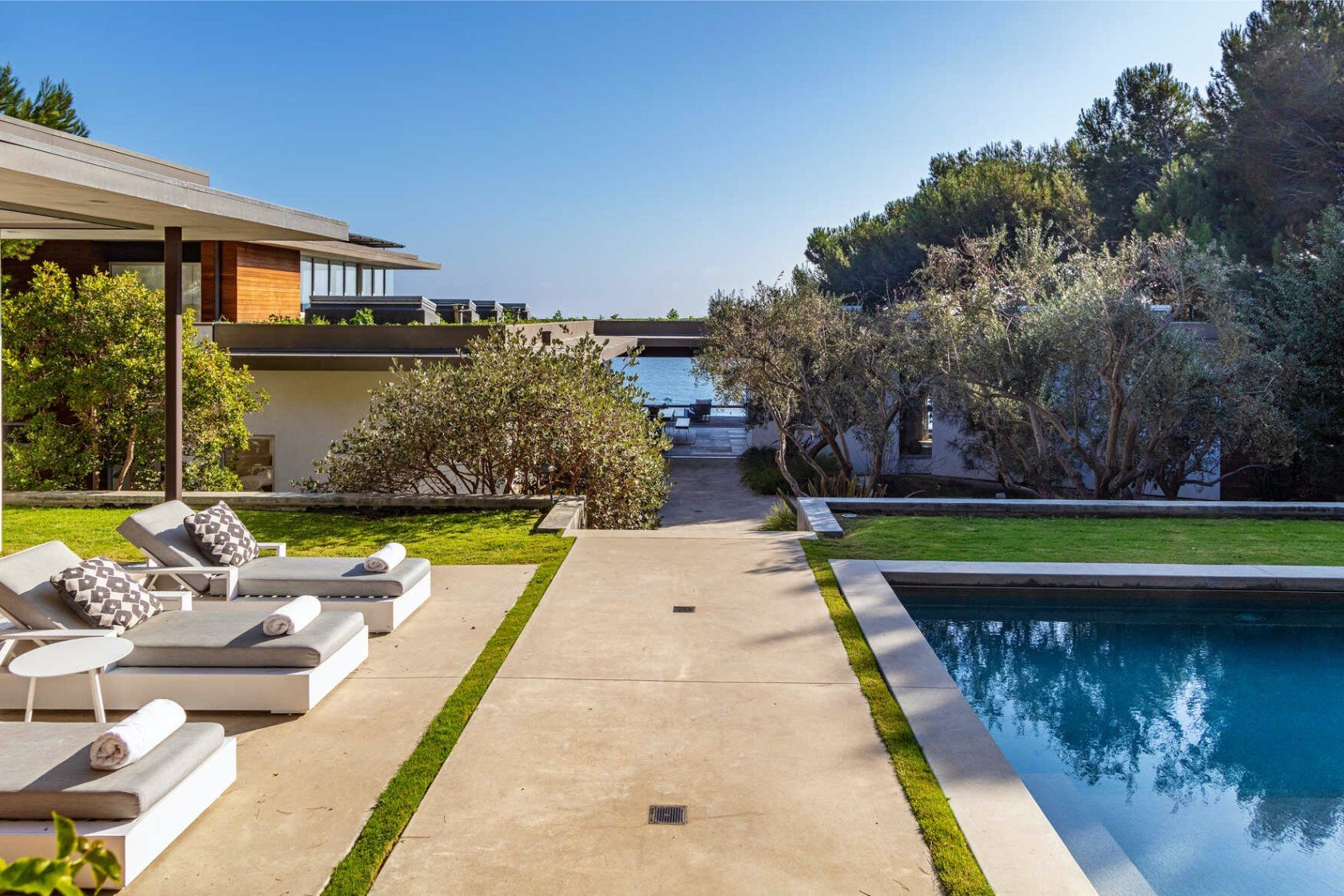 Piscina de una casa moderna con porche y vistas a la playa