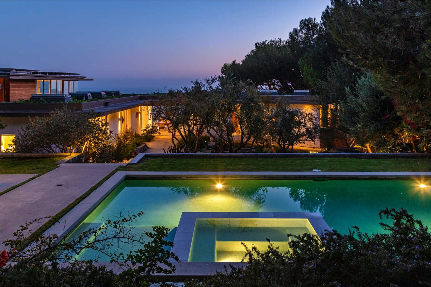 Piscina de una casa moderna iluminada por la noche