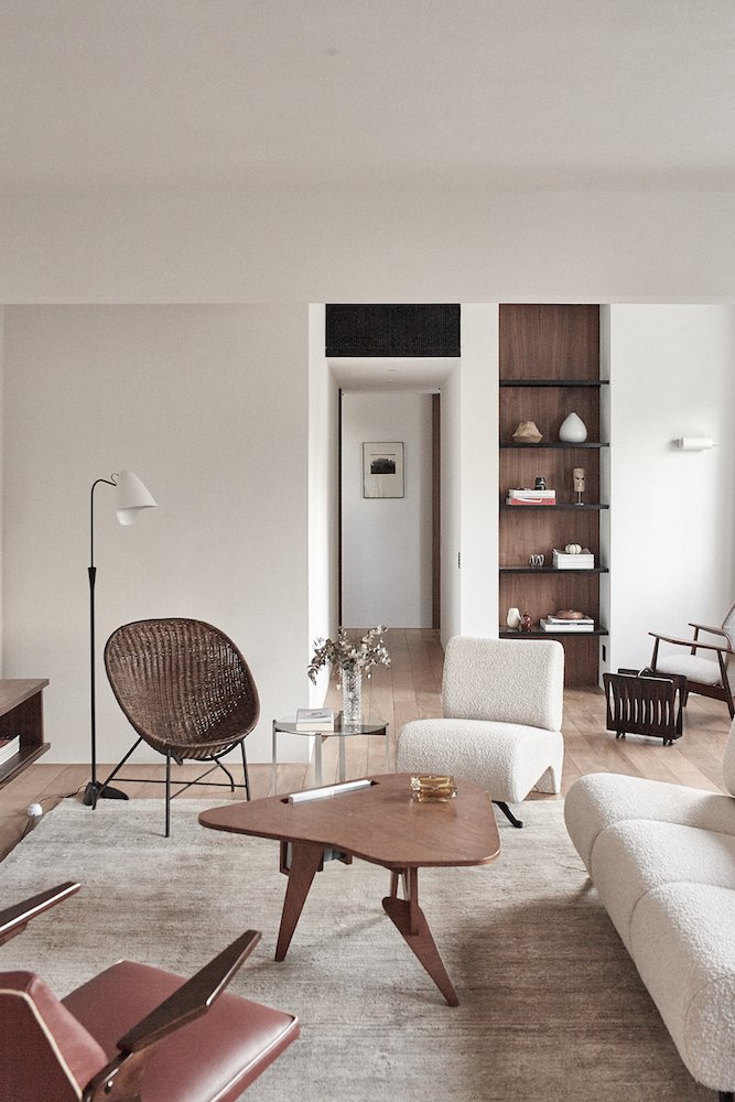 Piso con salon con sofa de tela blanca y mesa de cafe de madera