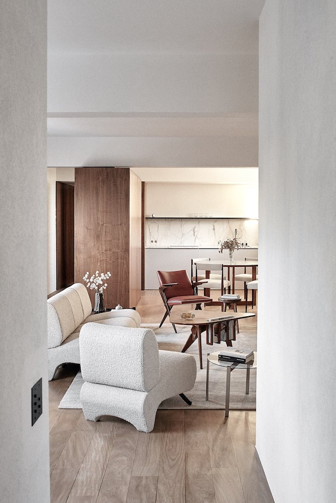 Piso salon con sofa blanco y cocina con muebles de color blanco