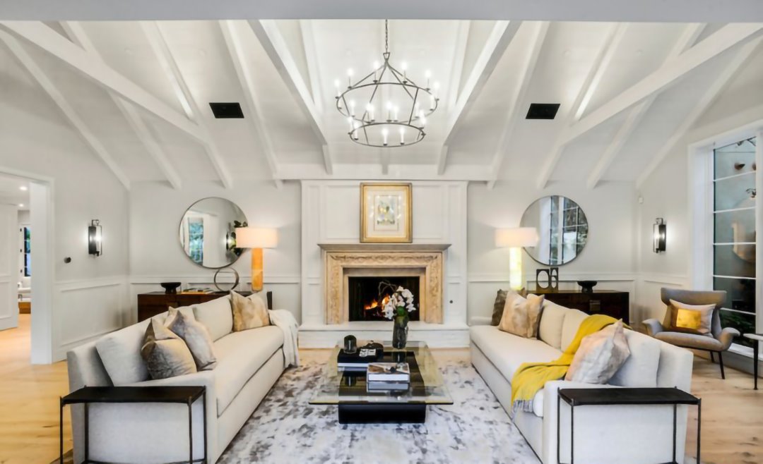 Salon con chimenea techo con vigas de madera casa Cameron Diaz