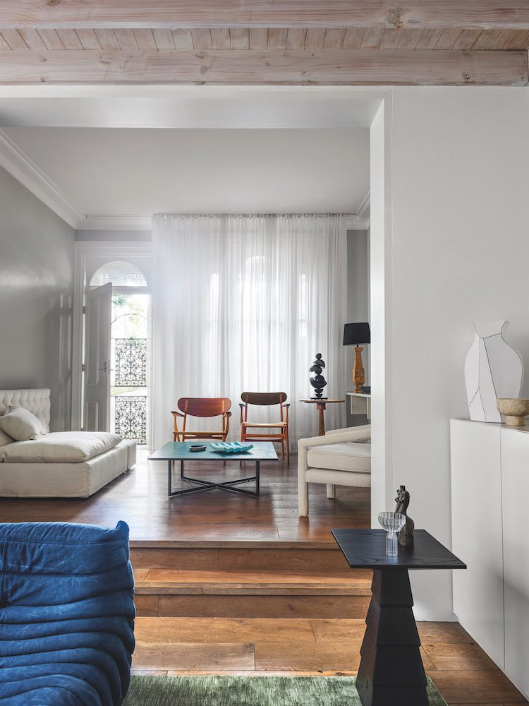 salon con dos alturas escalera de madera y techo con vigas