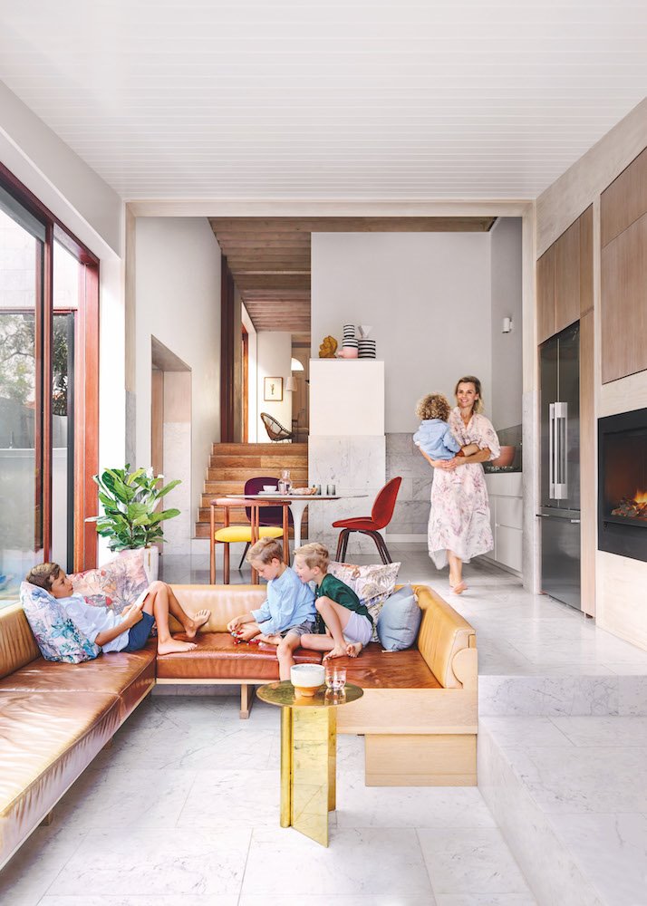 Salon junto a la cocina con sofas de obra con tapiceria de piel marron familia