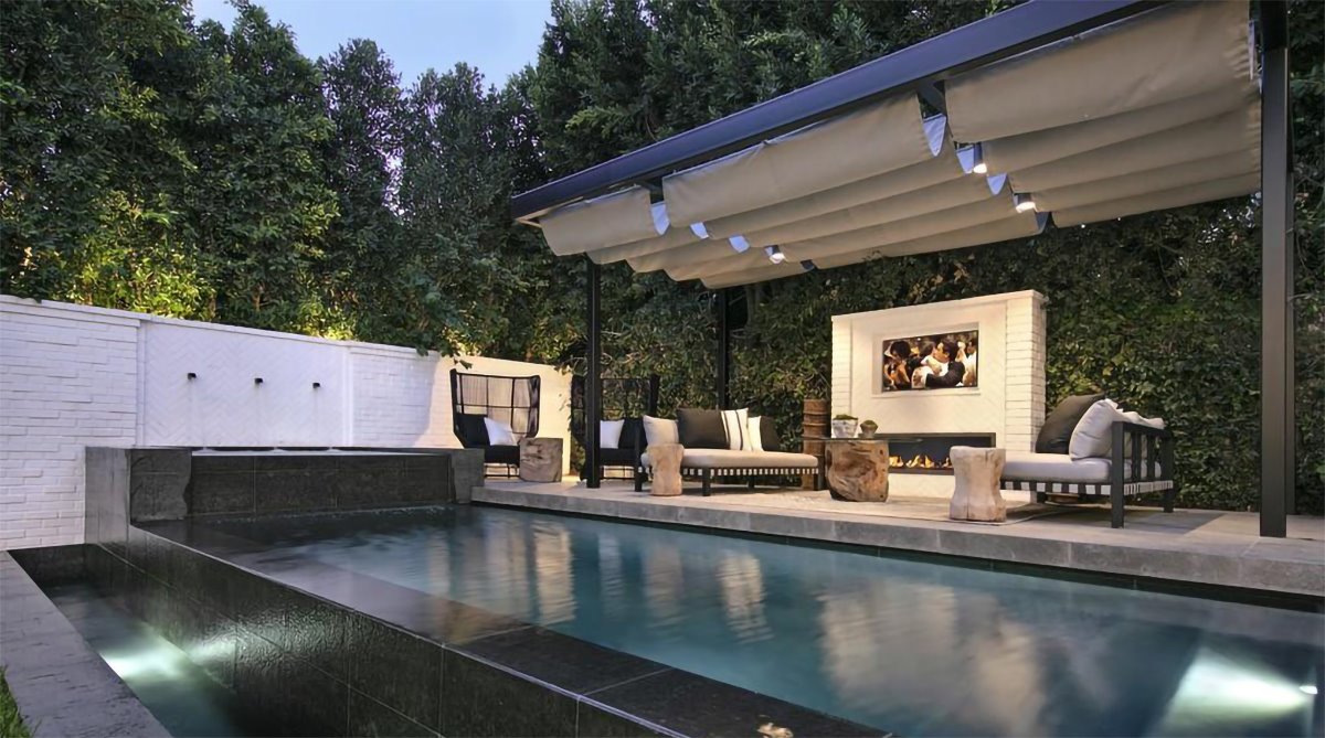 Comedor exterior con chimenea y piscina de la casa de Justin Bieber y Hailey Baldwin