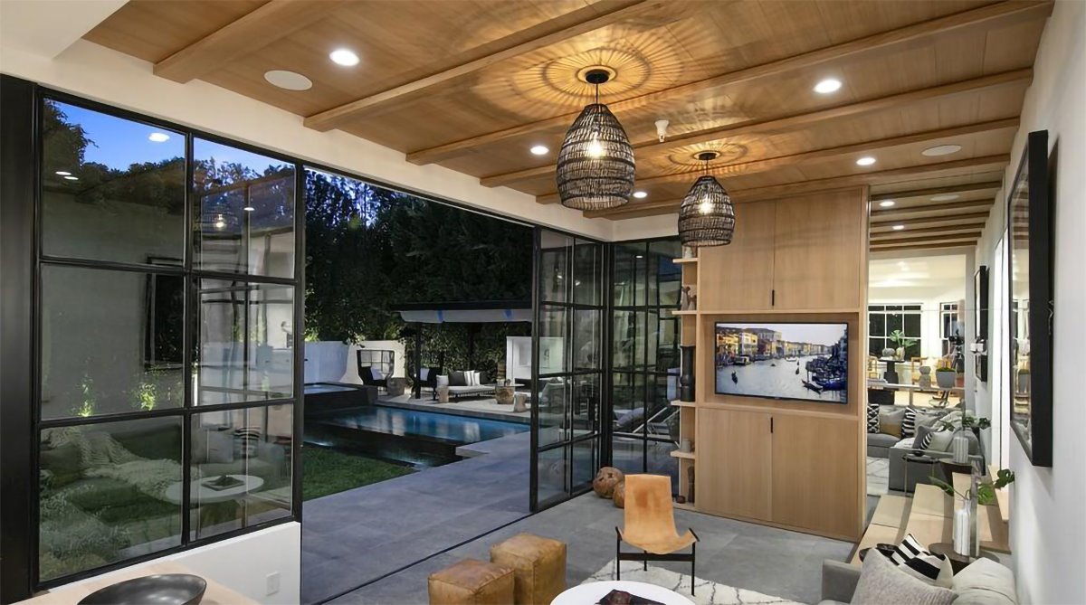 Estar con paredes de madera y lamparas de mimbre abierta al patio de la casa de Justin Bieber y Hailey Baldwin