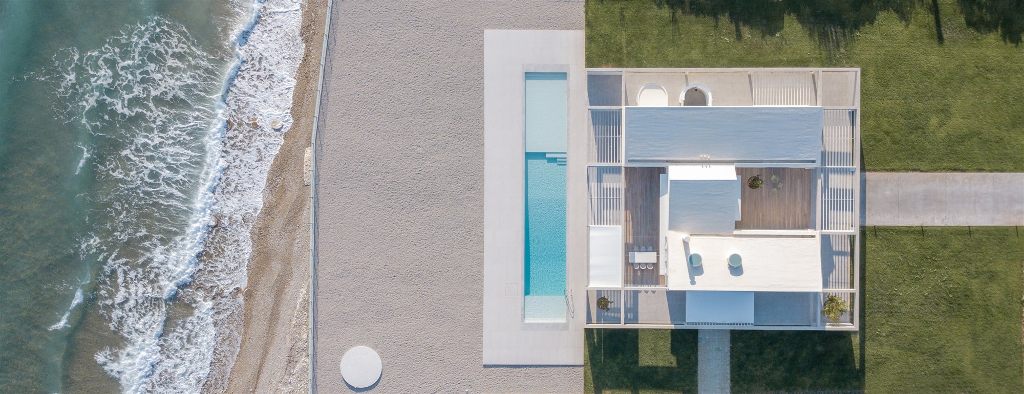 Vista aerea dron de una casa con piscina a pie de playa