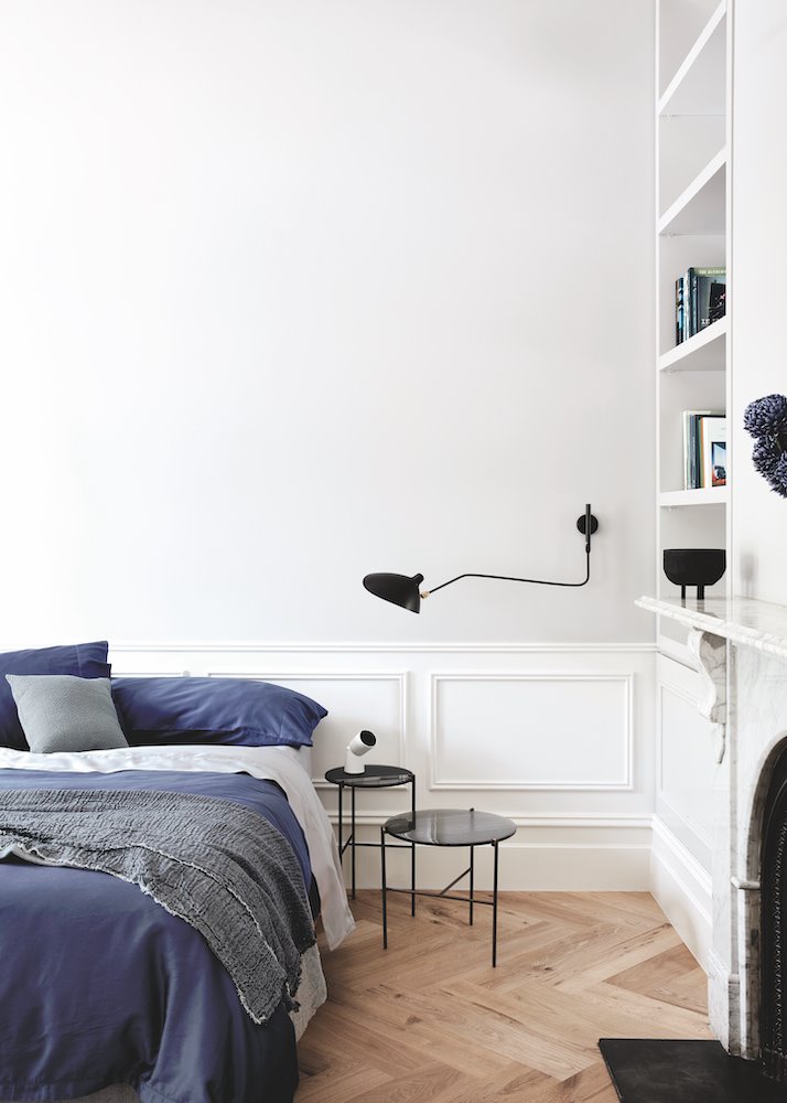 Dormitorio con molduras en la pared y lampara de pared de color negra