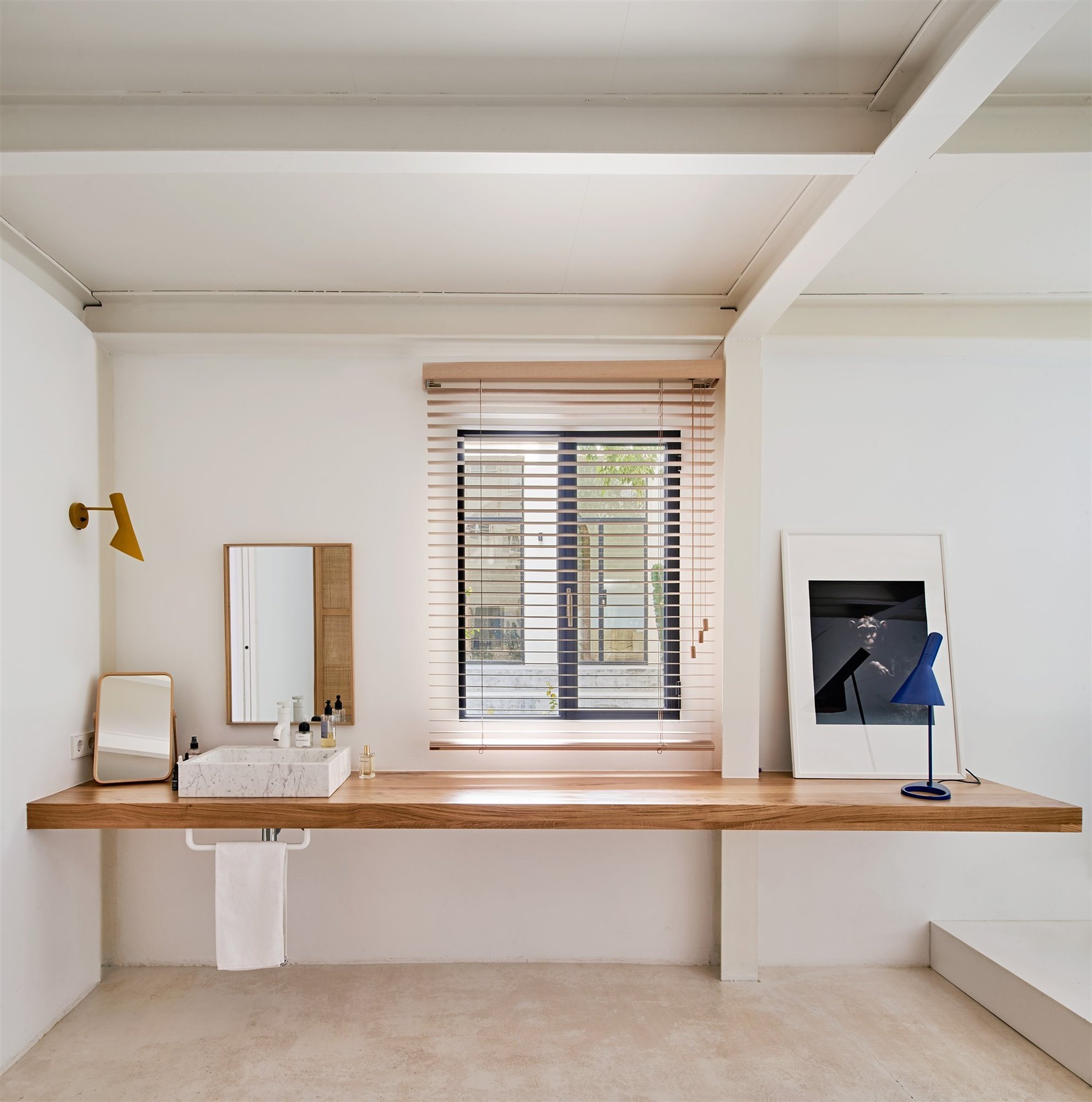 Baño con encimera de madera y ventana con lamas de madera