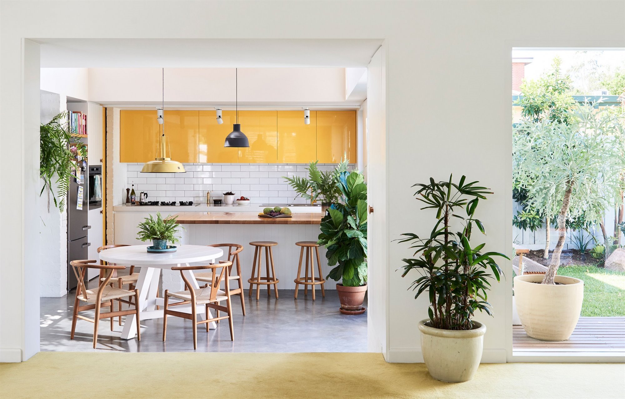 Cocina comedor con baldosas blancas y muebles de color amarillo