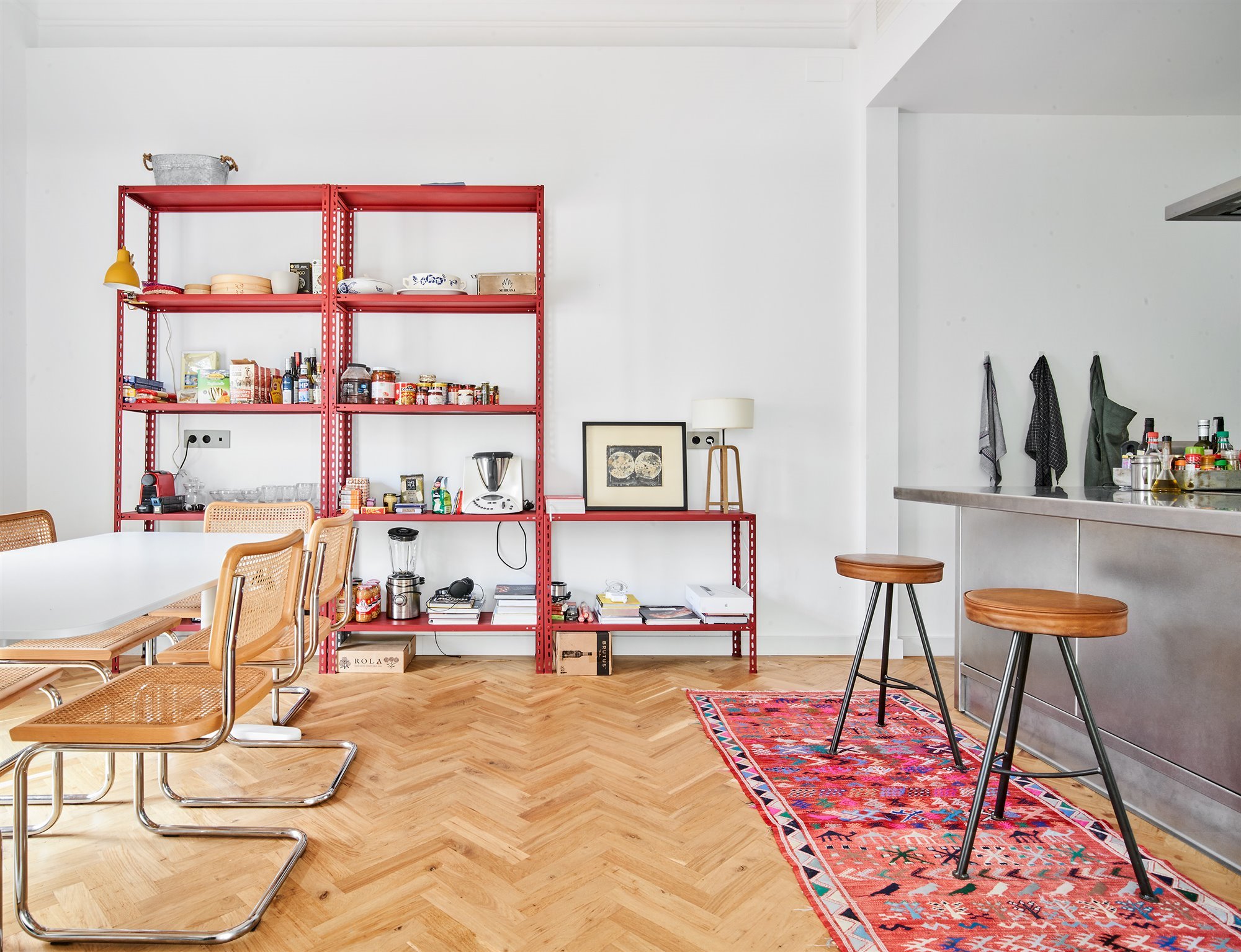Cocina de estilo industrial con muebles de acero y suelos de madera de espiga