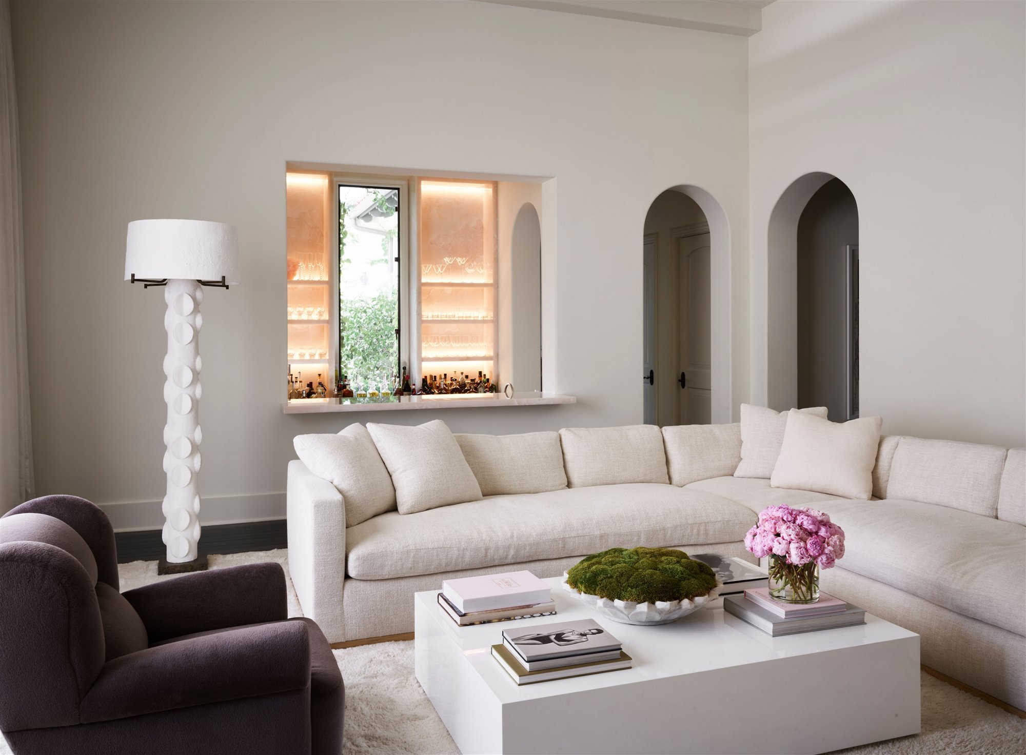 salon con arcos en la pared y sofa de color blanco de la casa Kourtney Kardashian en Calabasas