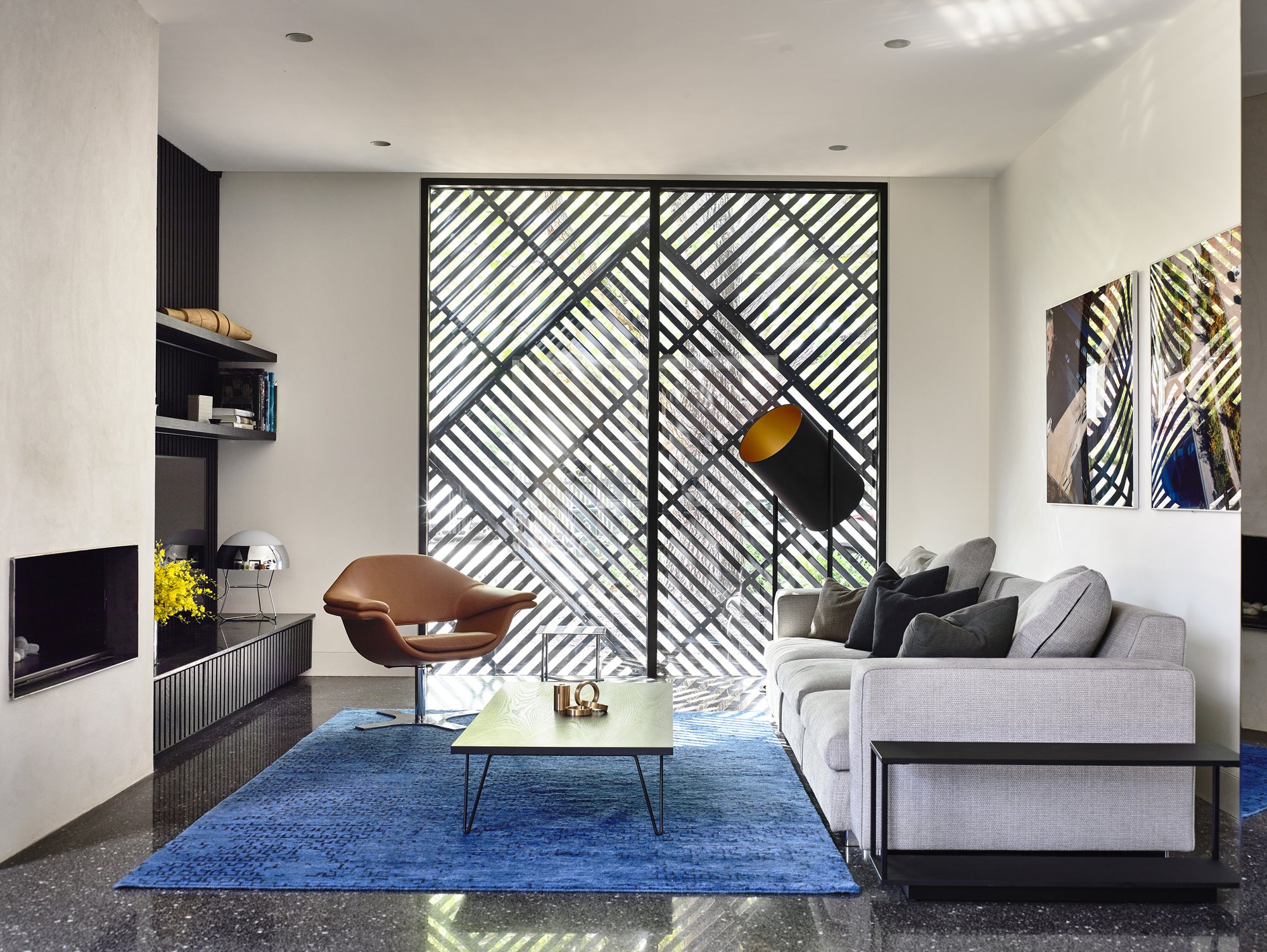 Ventana con celosias salon sofa gris alfombra azul