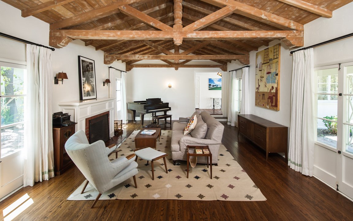 Casa con vigas vistas de la actriz Zooey Dischanel salon con chimenea