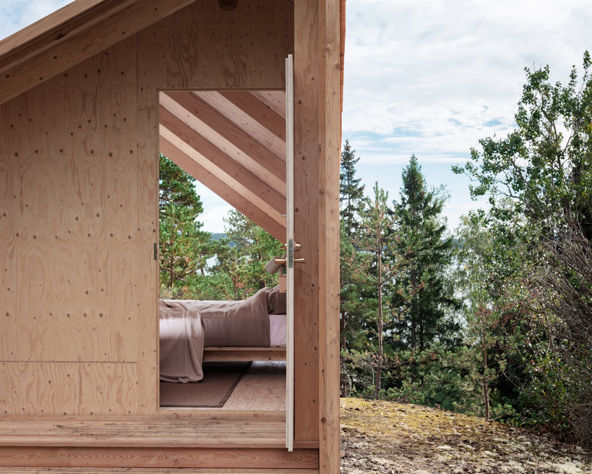 Cabaña de madera en mitad de un bosque con dormitorio